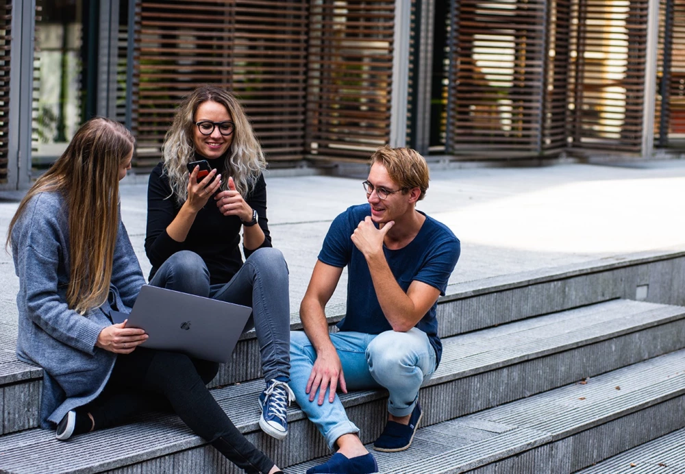 group of people sitting on stairs smiling