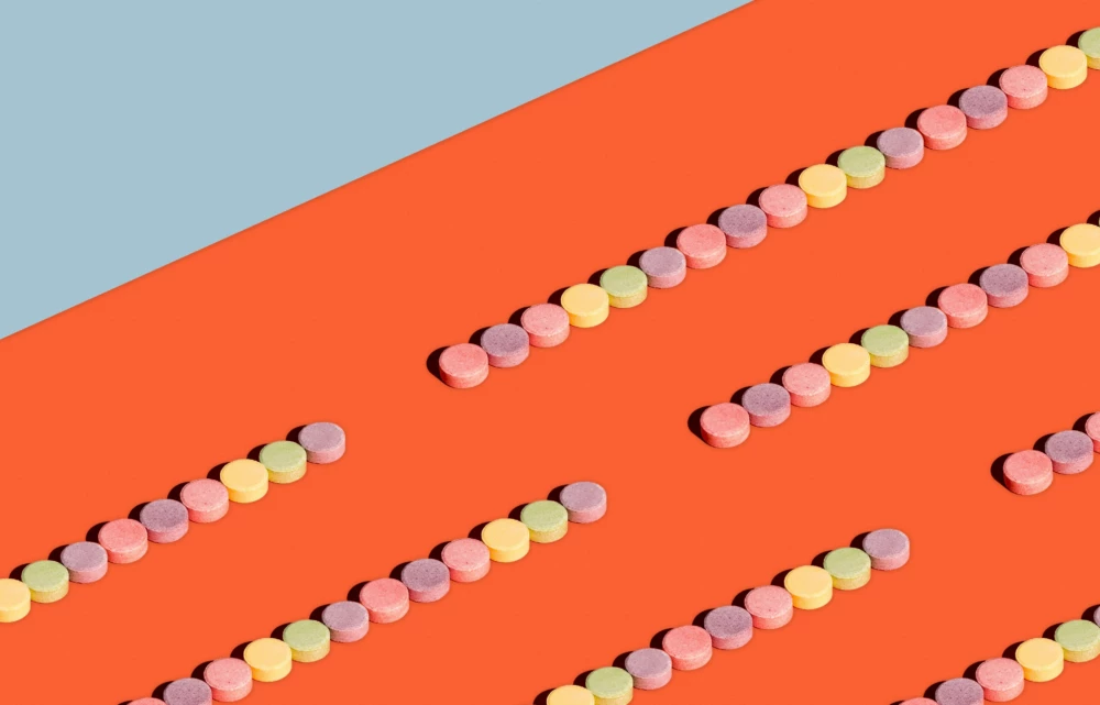 Pills lined up on orange surface