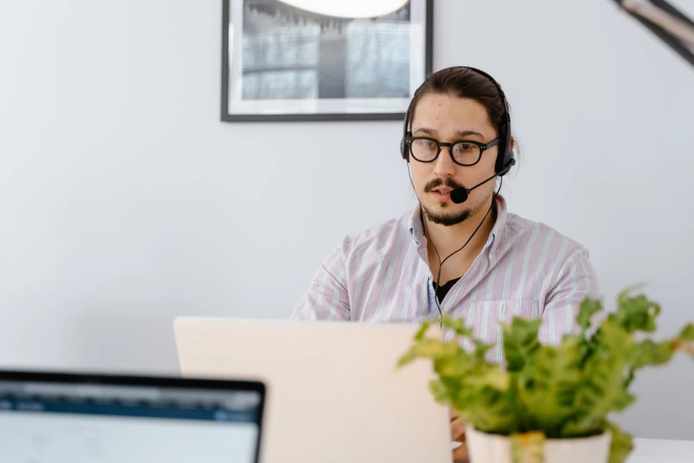 Person with a headset working on laptop