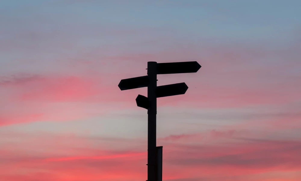 Direction sign at sunset