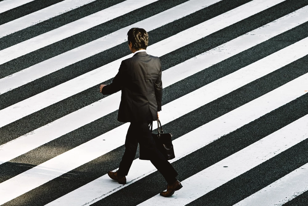 Business man walking in crosswalk