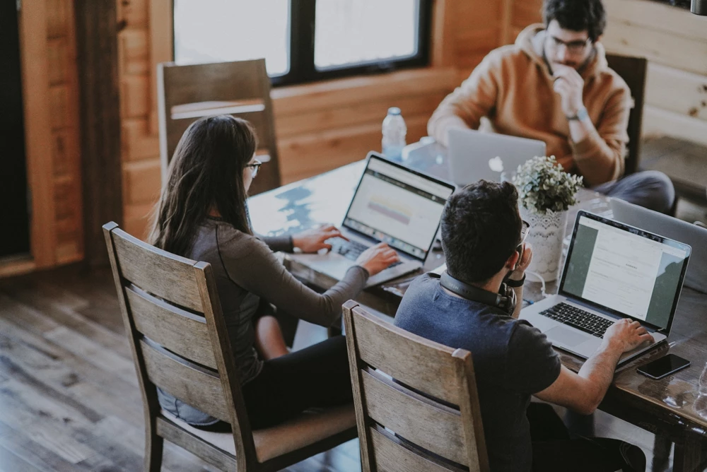 People with laptops at a table