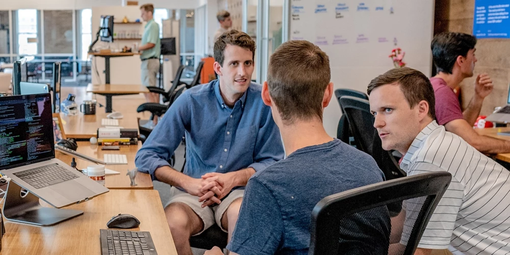 Coworkers talking around a desk